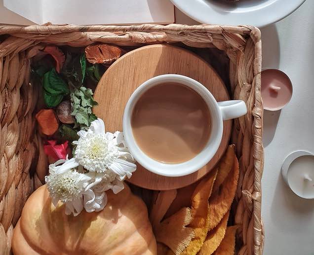 cup of coffee on tray with a croissant